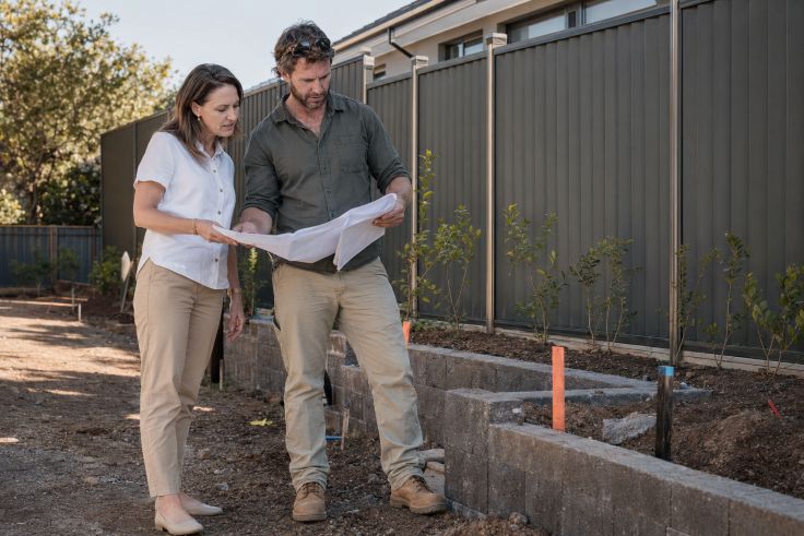 Homeowner and contractor review garden plans